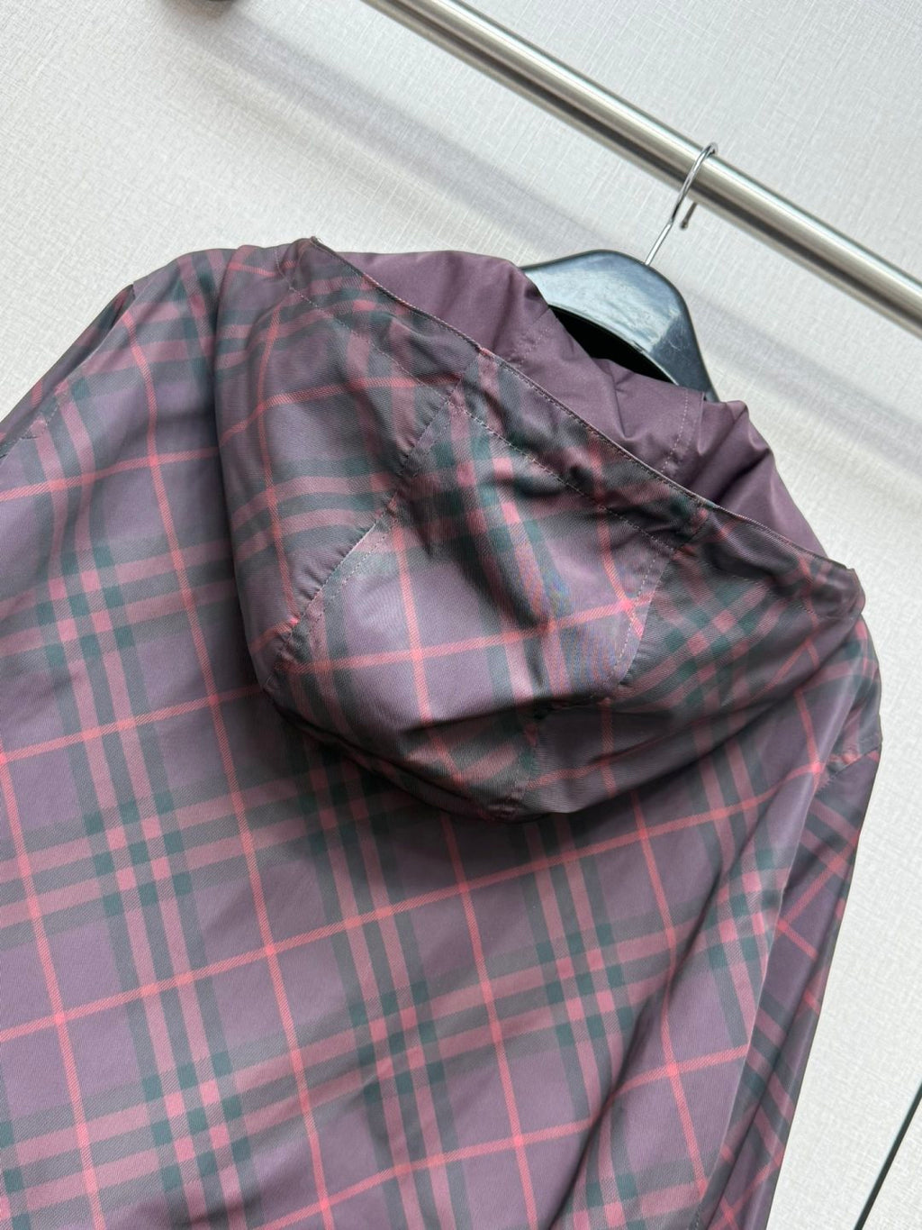 Burberry plaid hooded jacket with folded hood and zip front in dark purple.