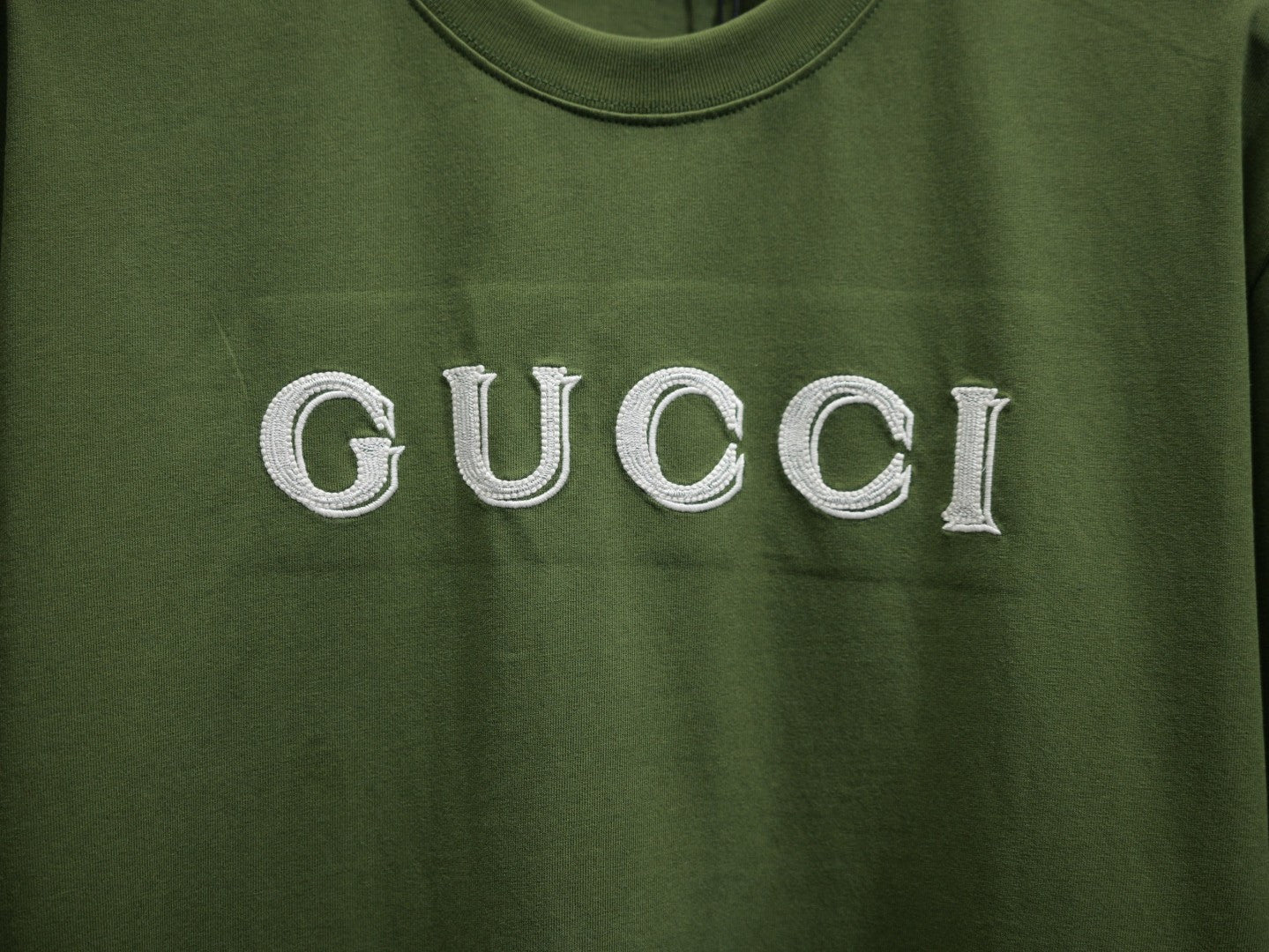 Olive green T-shirt with large white Gucci lettering