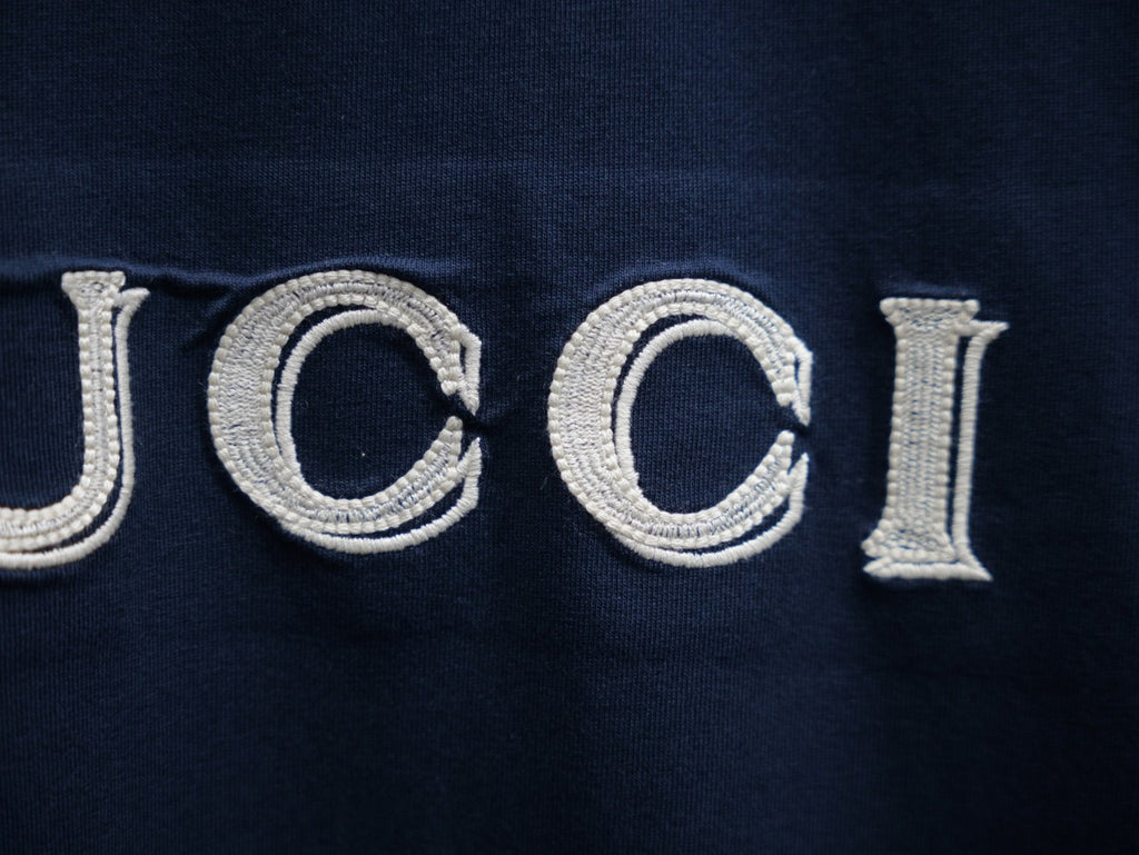 Embroidered GUCCI lettering on a dark navy short-sleeve T-shirt