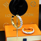 Louis Vuitton monogram hoop earrings on display stand with gold interior