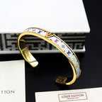 Louis Vuitton monogram cuff bracelet, gold-tone open cuff with multicolor patterned band