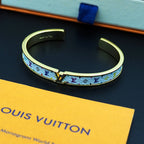 Louis Vuitton monogram cuff bracelet, gold-tone with multicolor logo pattern on blue backing