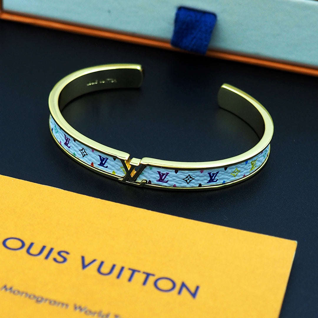 Louis Vuitton monogram cuff bracelet, gold-tone with multicolor logo pattern on blue backing