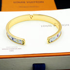 Louis Vuitton bracelet cuff with gold-tone finish and blue monogram trim on card