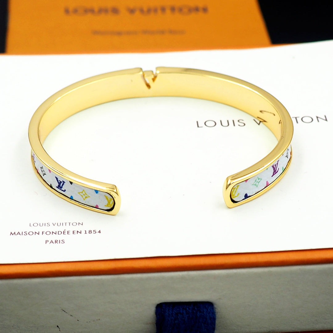 Louis Vuitton bracelet cuff with gold-tone finish and blue monogram trim on card