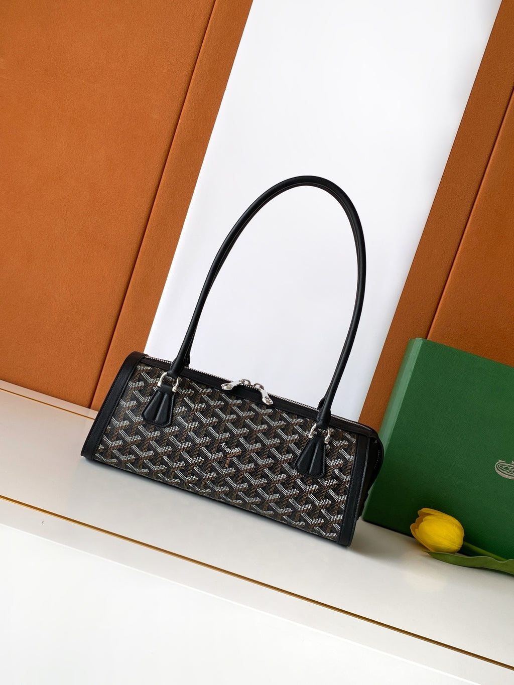 Goyard bag with top handles, black monogram pattern, and leather trim, open front.
