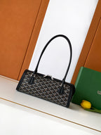 Goyard bag with top handles, black monogram pattern, and leather trim, open front.