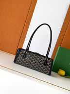 Goyard bag with top handles, black monogram canvas, and leather front trim.