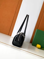 Goyard bag with long top handles and side profile, black monogram and leather trim.