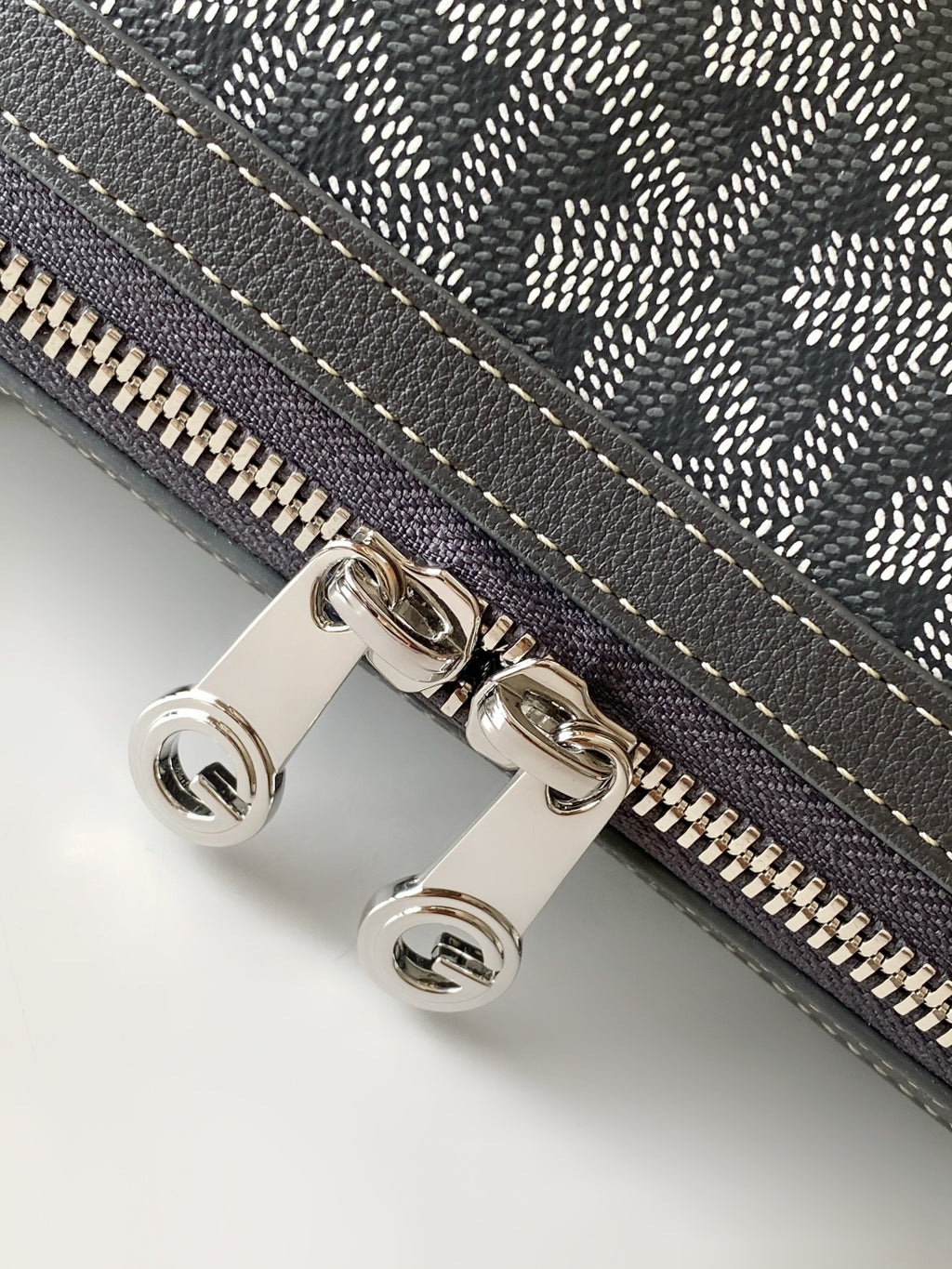 Zip-top monogram pouch with gold-tone zipper pull and snap buttons