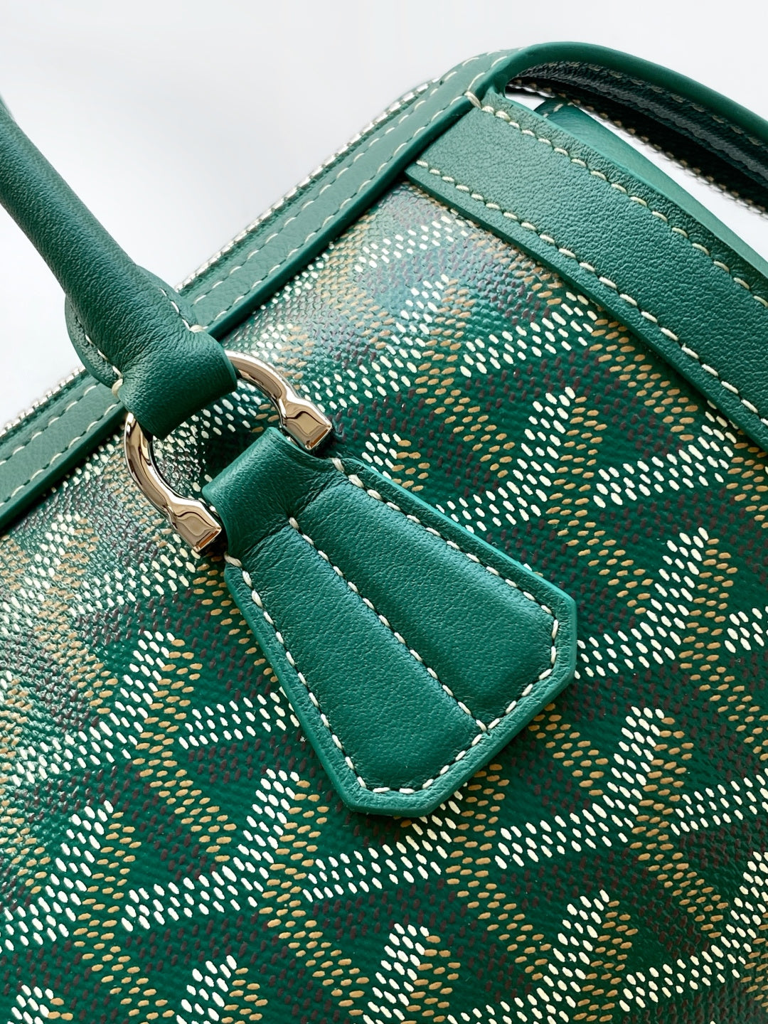 Goyard bag handle, dark green leather strap with stitching over patterned interior