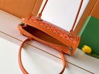 Orange Goyard top-handle bag with open zipper and patterned interior