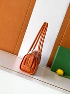 Orange Goyard mini tote bag with top handles and crossbody strap