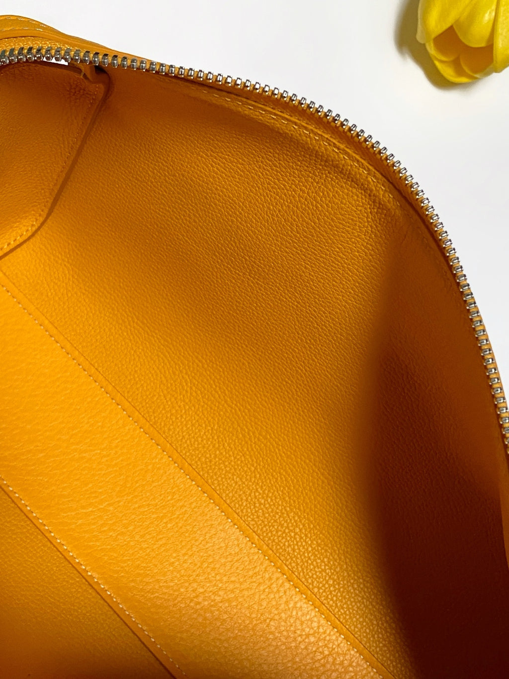 Goyard yellow leather handbag interior panel close-up with zipper edge