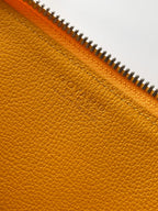 Goyard yellow leather handbag close-up of pebbled texture and zipper seam