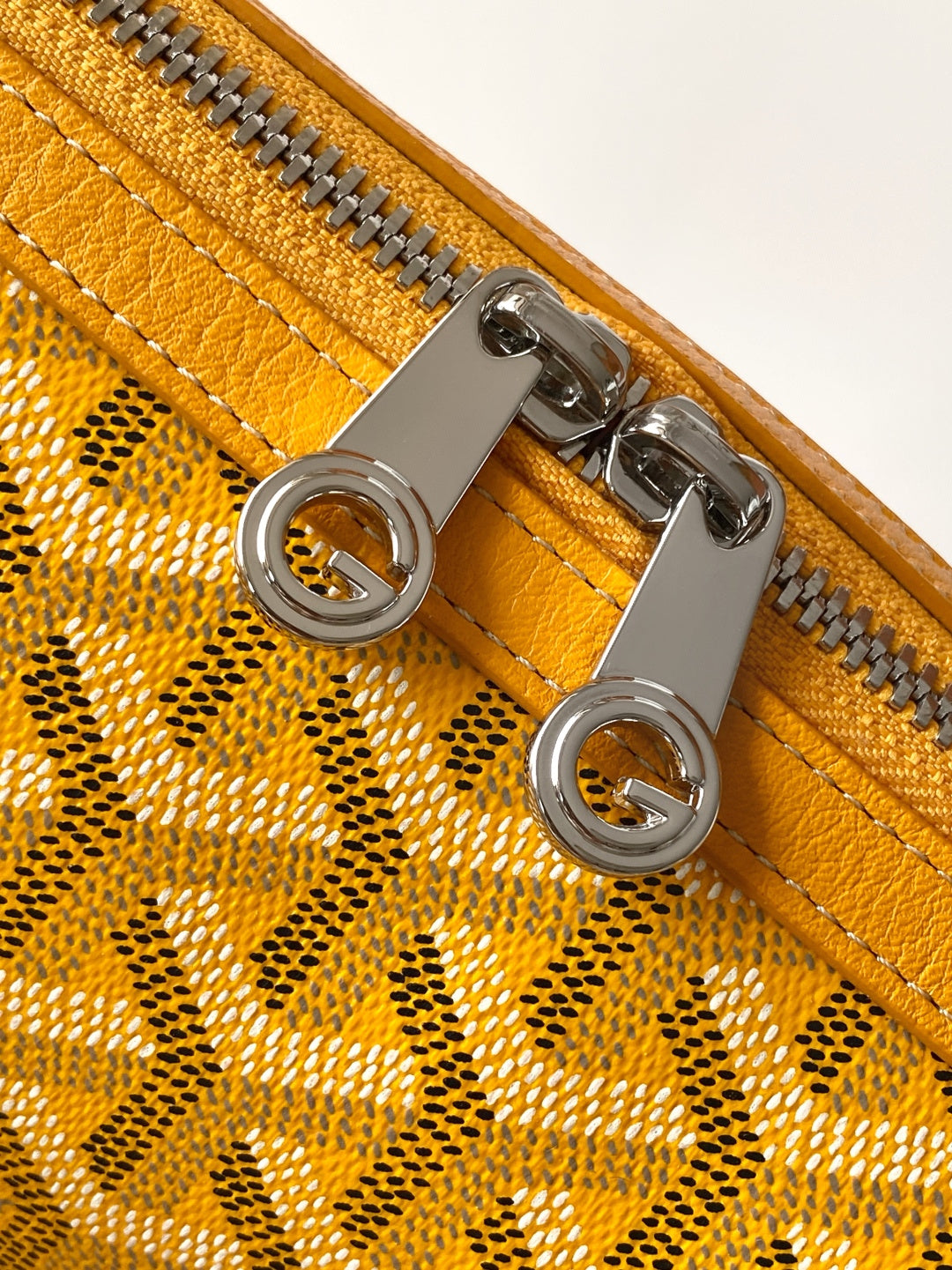 Goyard yellow handbag close-up of silver zipper pull and grommet hardware