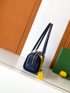 Goyard bag in navy with double handles and structured front, top zip closure.