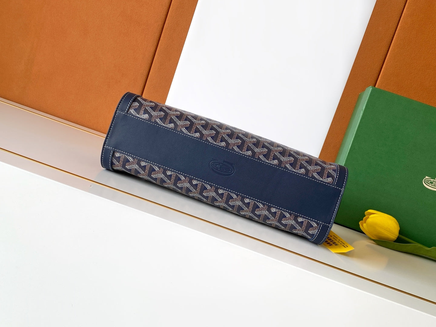 Goyard clutch bag with navy patterned trim, long strap, top fold-over flap.