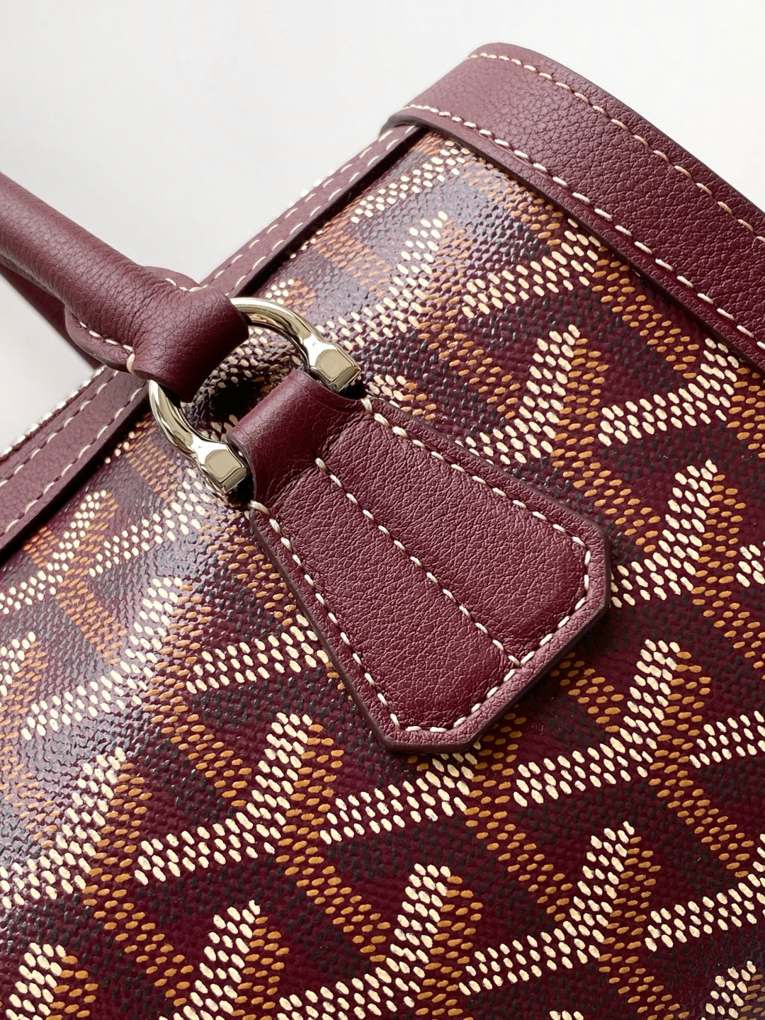 Burgundy leather trim over patterned canvas with silver buckle clasp detail