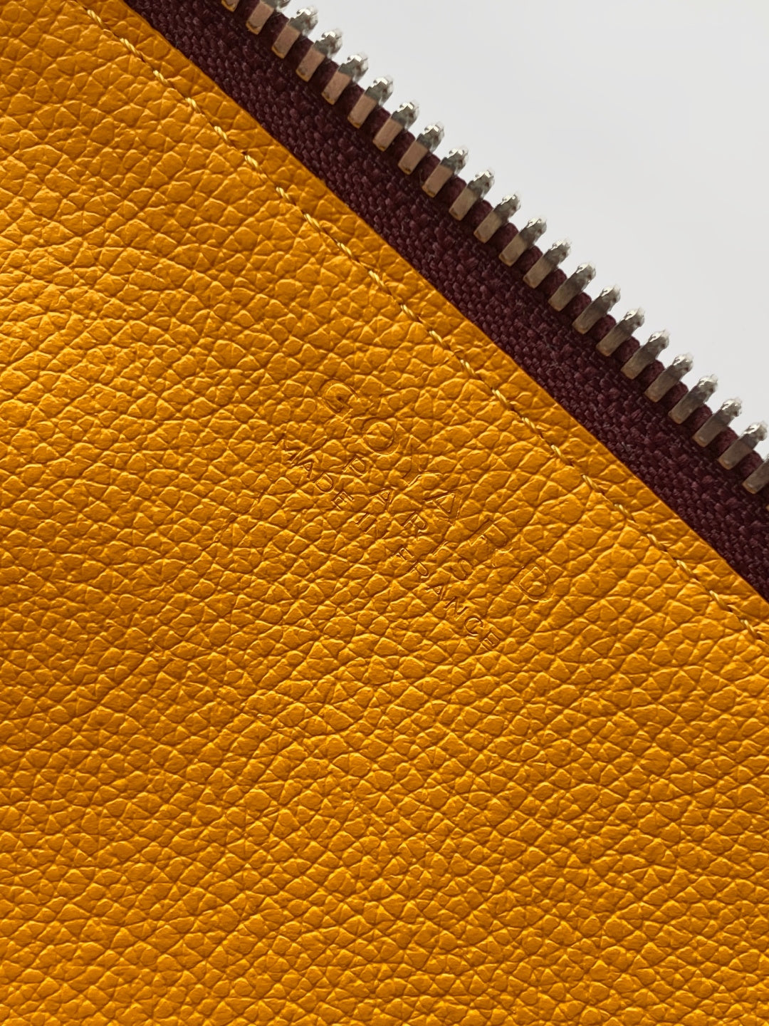 Yellow leather lining detail with zipper track and brown trim
