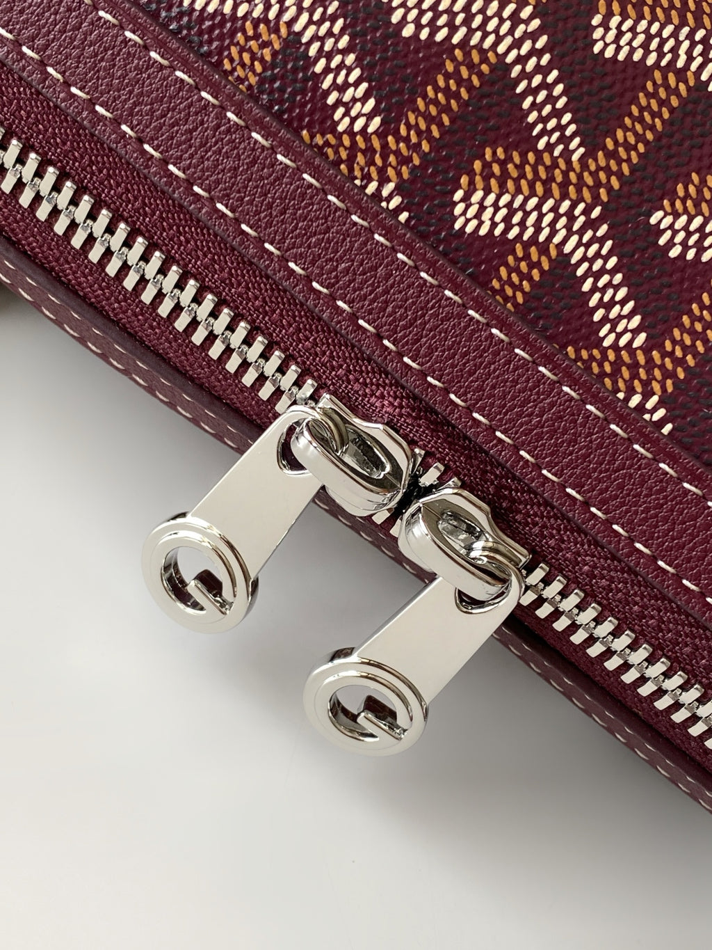 Burgundy zip pocket detail with silver hardware and stitched edge