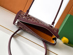 Burgundy logo handbag with crossbody strap and dual zip pockets