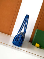 Blue Goyard small bag with top zipper and short shoulder strap, side view