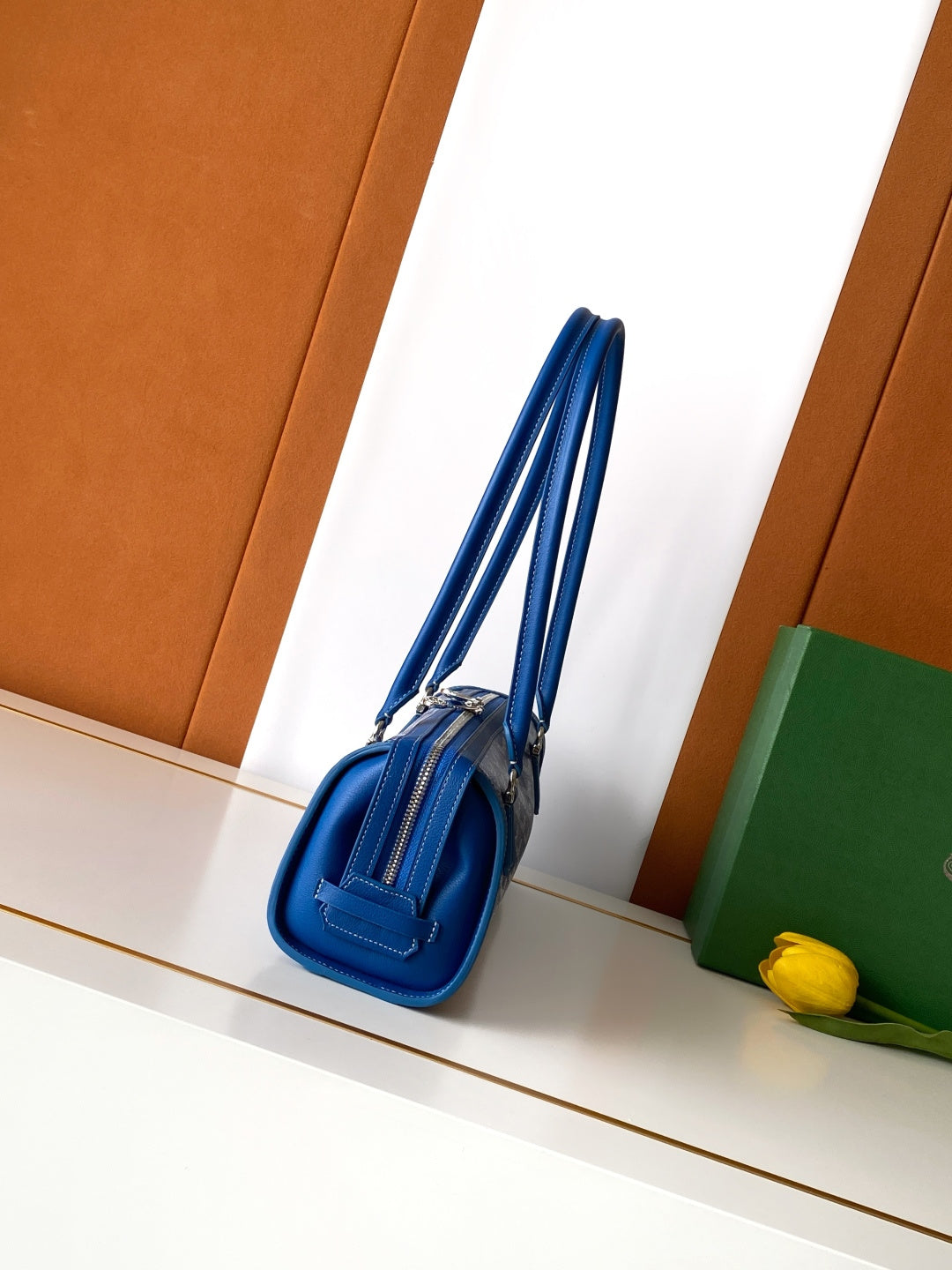 Blue Goyard small bag with top zipper and short shoulder strap, side view