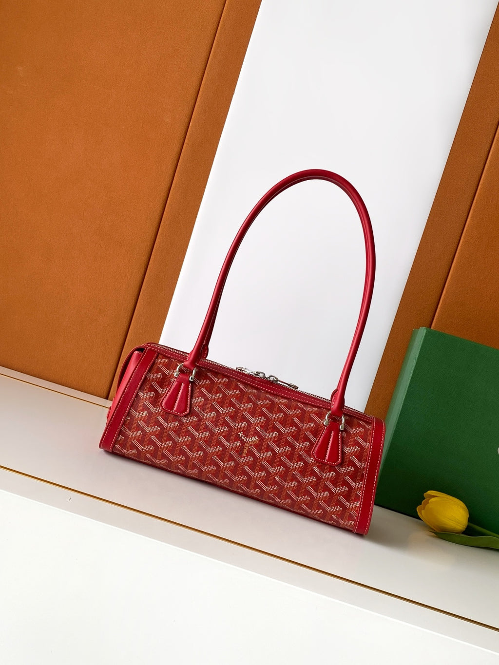 Red Goyard-style tote bag with top handles and front patterned canvas