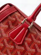 Red patterned handbag with leather pocket detail and silver-tone hardware on front