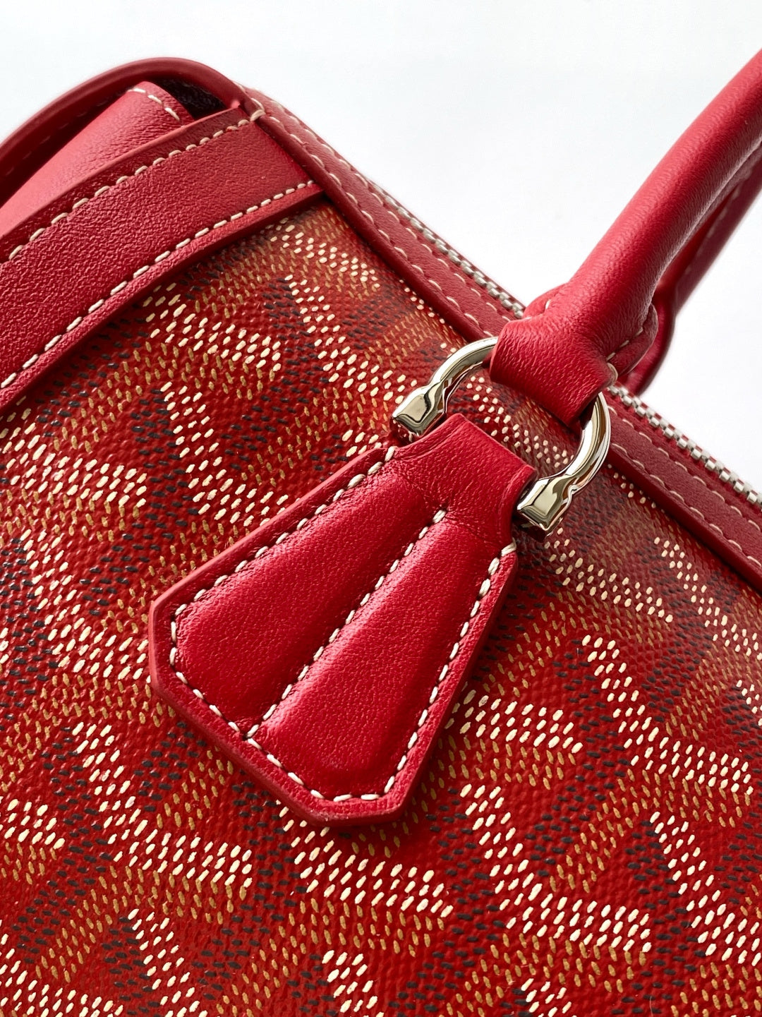 Red patterned handbag with leather pocket detail and silver-tone hardware on front