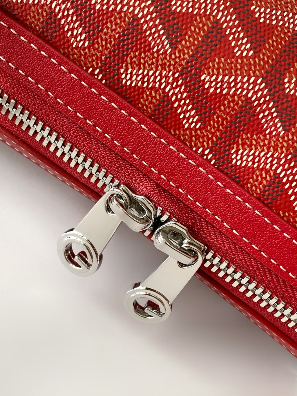 Red handbag with silver-tone zipper hardware and double-stitched trim