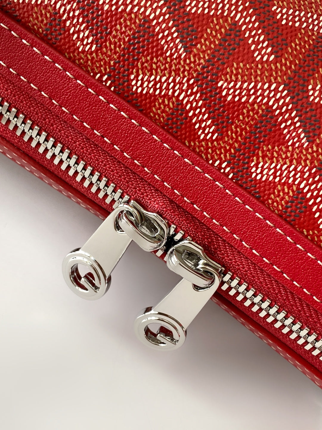 Red handbag with silver-tone zipper hardware and double-stitched trim
