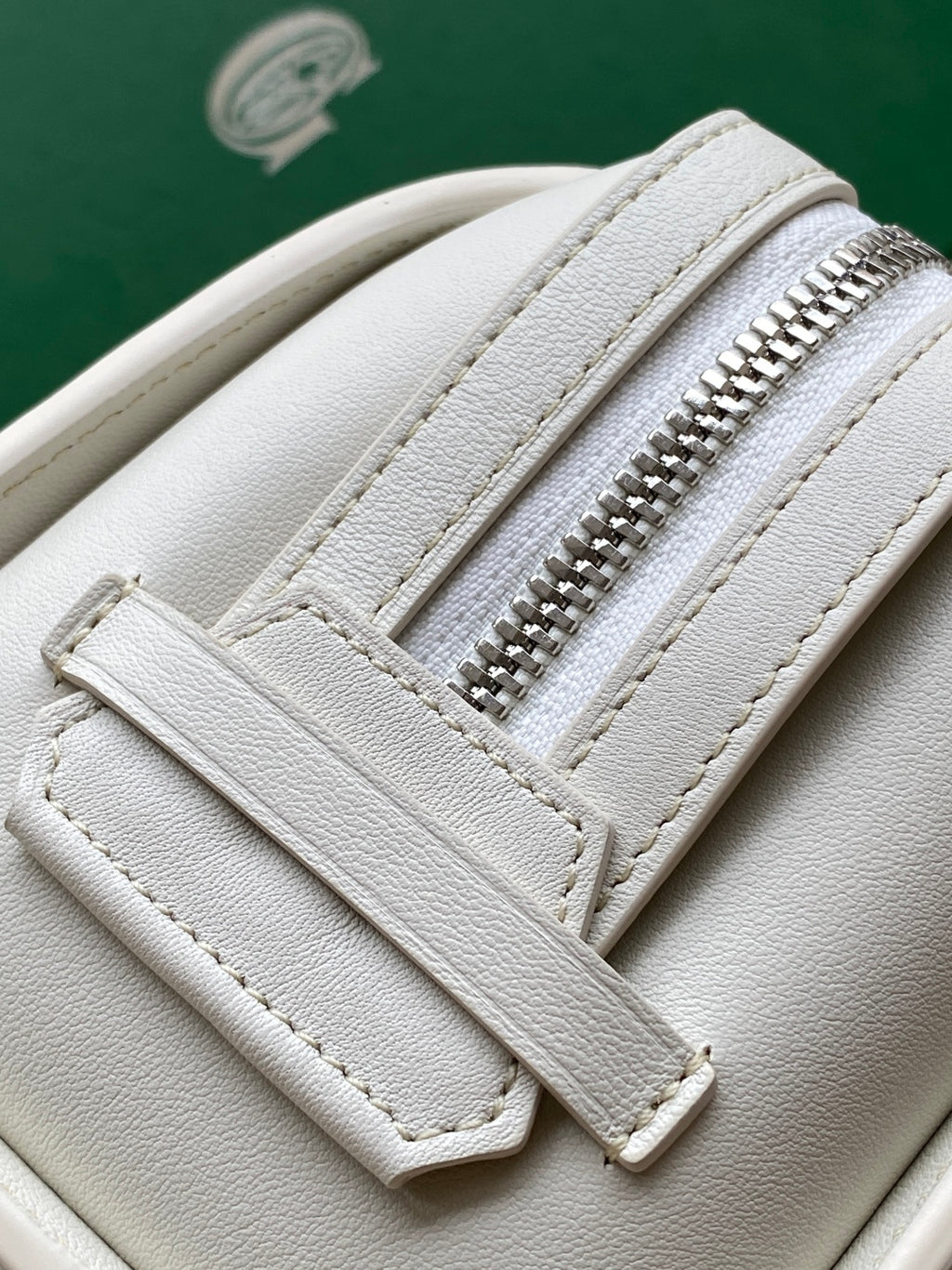 Goyard white leather bag close-up with zipper teeth and stitched seams