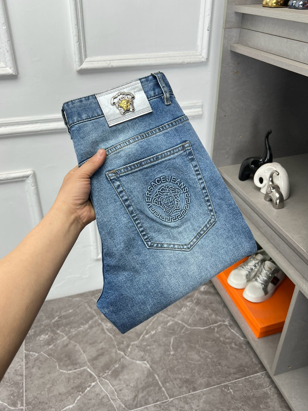 Versace light blue denim jeans with rectangular logo patch on waistband