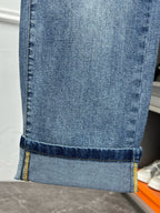 Versace light blue denim jeans hem with contrast stitching and cuff fold
