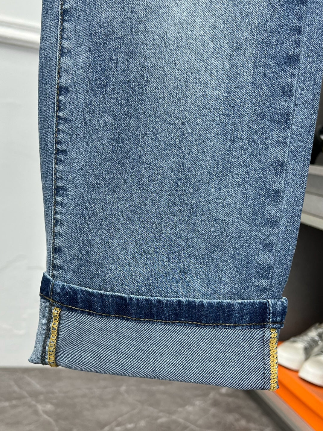 Versace light blue denim jeans hem with contrast stitching and cuff fold