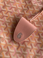 Pink patterned canvas with a tan leather tab and round logo emblem