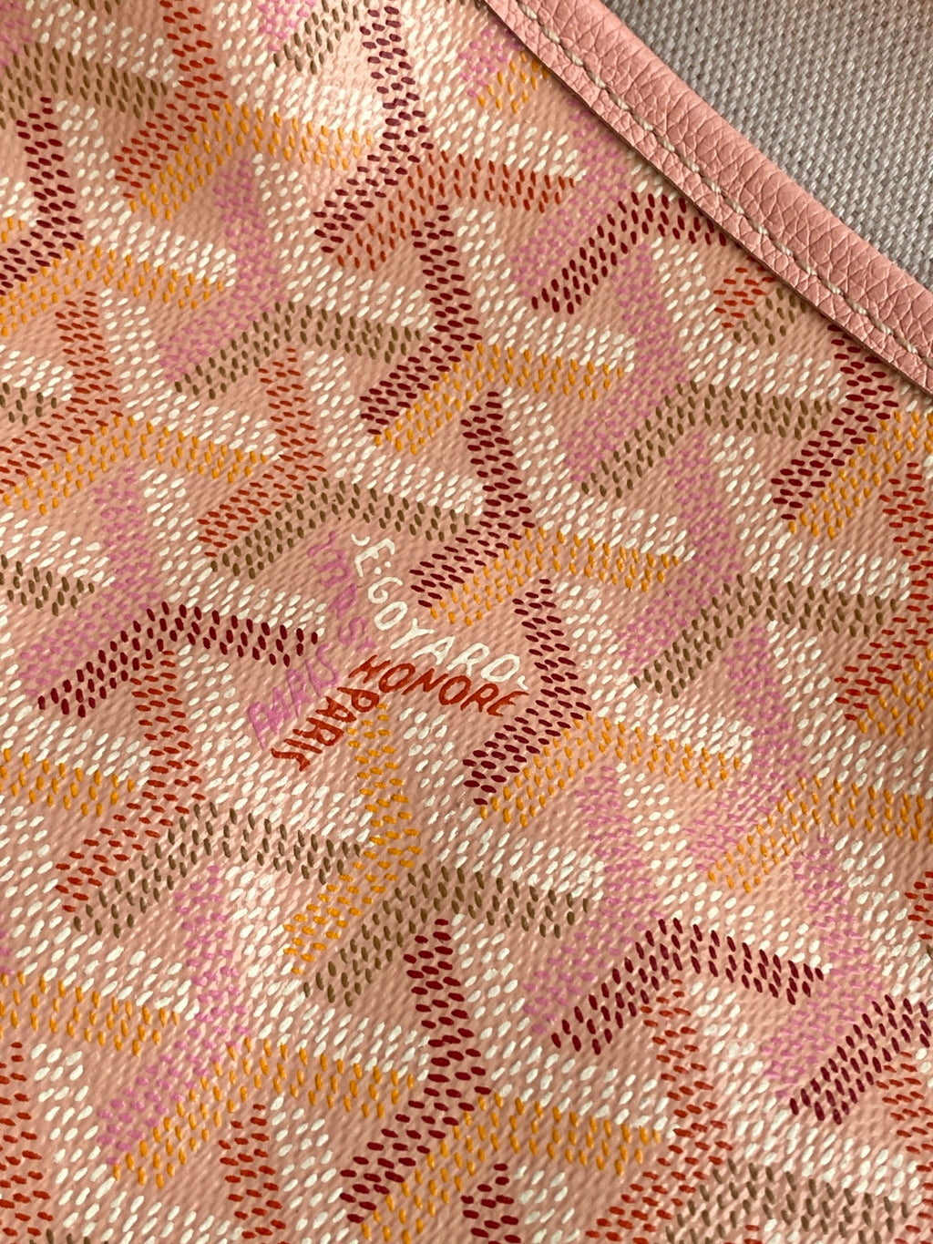 Pink patterned canvas with embossed lettering logo on the bag