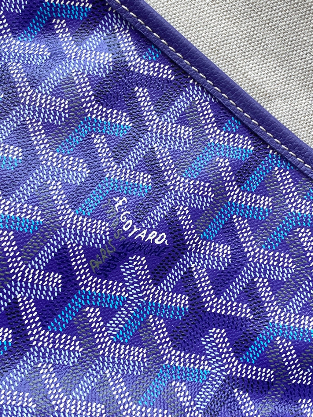 Purple monogram canvas with stitched edge trim and small logo print