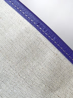 Purple leather trim with contrast stitching on textured canvas