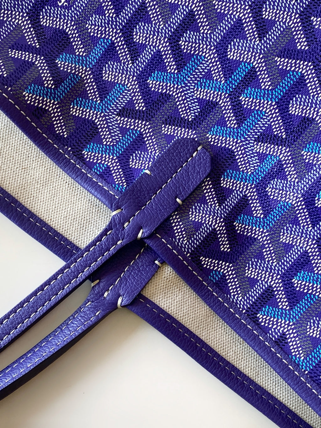 Purple monogram tote bag with cross-stitched handle attachment and piping