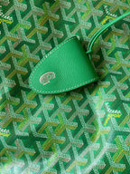 Goyard green leather tab with stitched emblem on patterned canvas tote