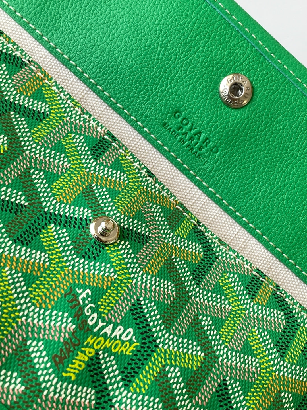 Goyard green leather strap end with metal snap and logo on patterned canvas