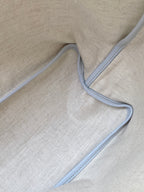 Light beige interior lining of a light blue patterned tote bag with piping