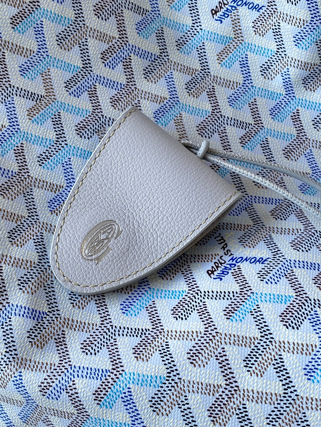 Light blue patterned pouch with light gray leather patch and stitched edge
