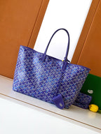 Blue patterned tote bag with leather-trim handles and front logo patch