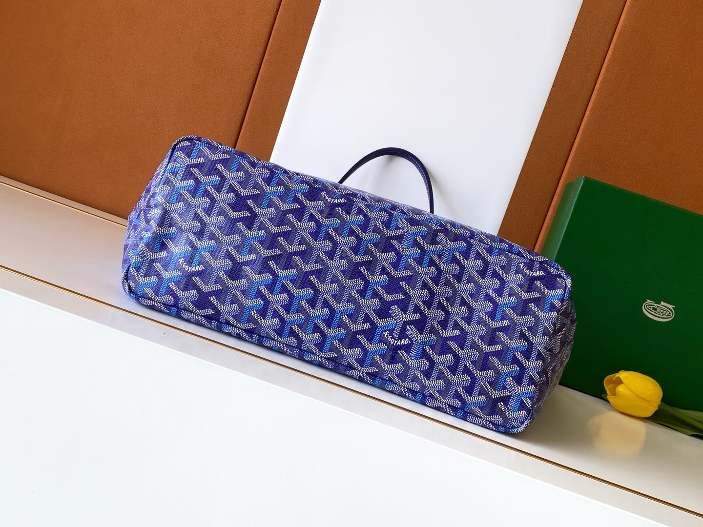 Blue patterned tote bag with wide base and top handles, angled profile