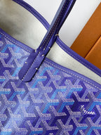 Blue patterned tote bag with purple leather trim and stitched strap attachment