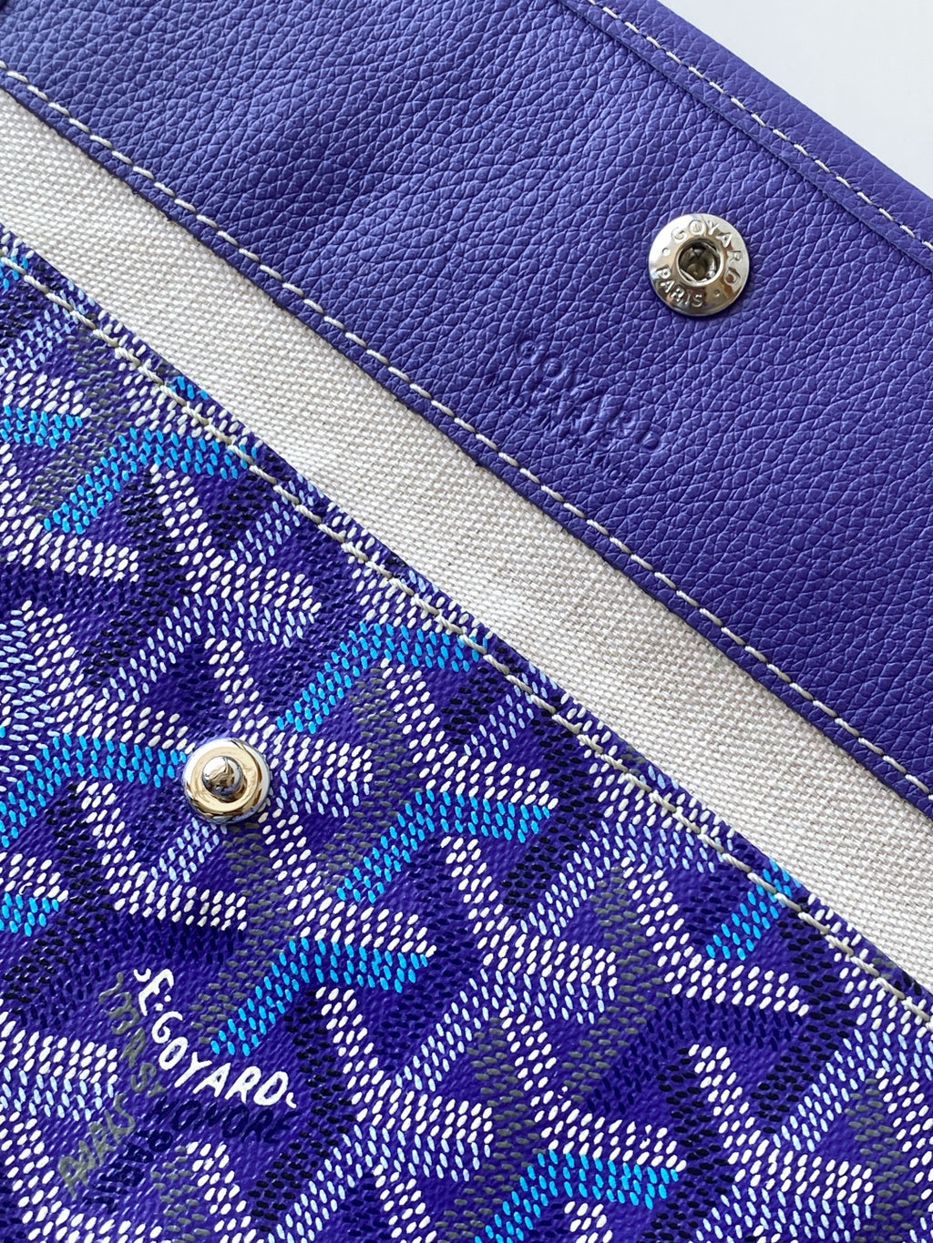 Blue patterned tote bag panel with purple leather accents and metal snap studs